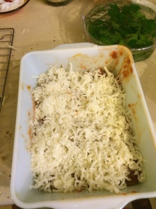 cheeses on top of first layer of eggplant rounds and sauce. Next step is to repeat the whole process.