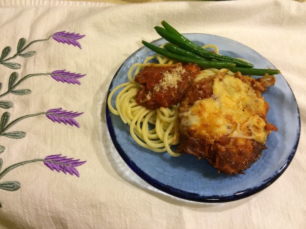 Plated Eggplant Parmesan with fresh pasta and green beans.